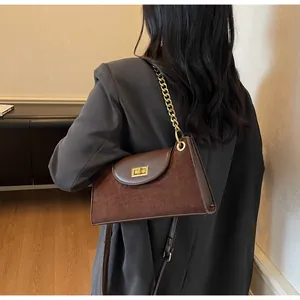 Detail view of the elegant leopard print baguette bag with gold metal chain and twist lock