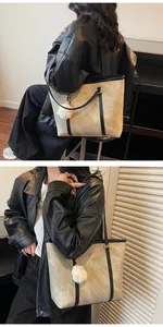 Detail of minimalist oatmeal tote bag with soft texture, black straps and fur charm