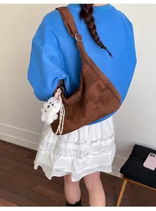 Sac hobo rétro marron avec bandoulière réglable et breloque ours porté par un mannequin