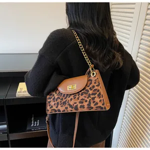 Detail of leopard print faux fur handbag with leather trim and gold chain strap