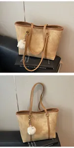 Detail of vintage camel tote bag with soft suede texture and gold fashion logo