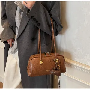 Bolso Boston de cuero marrón con herrajes dorados y logotipo de marca Maven & C