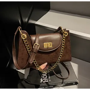 Macro shot of stylish faux leather baguette bag with metal gold chain and rotating lock