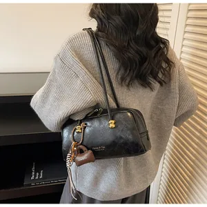 Detalle del bolso Boston vintage de cuero mate con cierre dorado y mini monedero extra