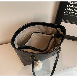 Detail view of large black tote bag interior showing beige compartments and zipper divider
