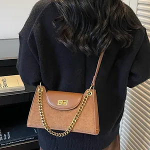 Brown faux suede baguette bag with asymmetric flap and golden chain strap