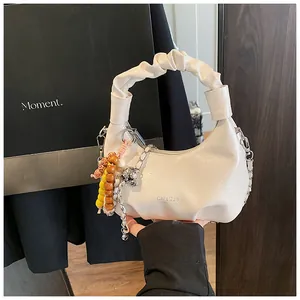 Detail of off-white pleated dumpling bag with silver chain and colorful bead charm