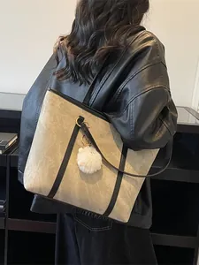 Minimalist large grey tote bag with black leather straps and white pompom on model