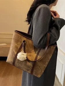 Brown vintage tote bag with marble texture, plush pendant, and dark leather trim