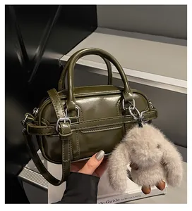 Détail du sac bowling vert olive brillant avec boucle argentée et breloque lapin
