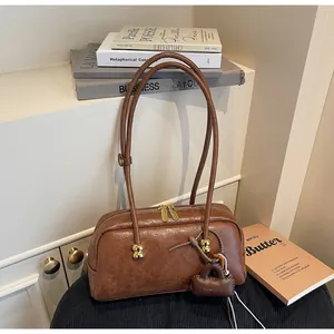 Primer plano detallado del bolso Boston vintage marrón con herrajes dorados y adorno
