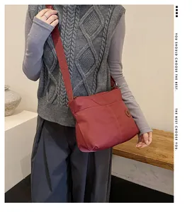 Detail of reddish-brown nylon tote bag featuring wide jacquard woven shoulder strap
