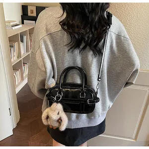 Vue détaillée du mini sac Boston en cuir verni noir avec charmant lapin en peluche