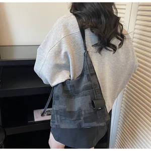Detail of woven texture tote bag in black and grey with small attached pouch and strap
