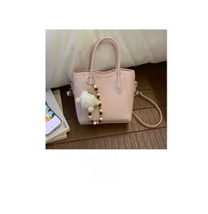 Détail du sac seau en similicuir rose avec charm gnome en peluche et bandoulière