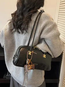 Bolso Boston vintage de cuero negro con detalles dorados y colgantes decorativos