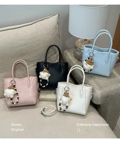Vue détaillée de quatre sacs seaux en cuir colorés avec breloques poupées et perles