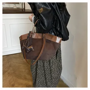 Λεπτομέρεια μεγάλης καφέ σουέτ τσάντας tote με διακοσμητικό σκύλο σε σκηνή καθημερινότητας