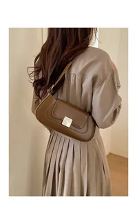 Detailed view of the dark brown leather baguette bag with a square metal buckle clasp