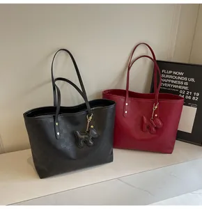 Detail view of large tote bags with checkerboard pattern and cute dog charms in black and red