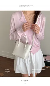 Détail d'un sac seau en cuir blanc avec bordure ondulée porté par un mannequin au style doux