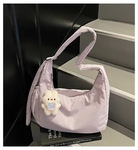 Detail of lavender puffer hobo bag with nylon texture and cute plush rabbit keychain