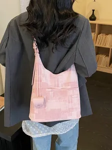 Pink textured large capacity tote bag worn by a model in a cozy interior setting