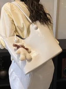 White large capacity tote bag with glossy texture and teddy bear charm on model