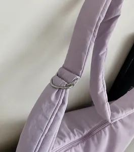 Close-up of the silver metal ring buckle and shiny lavender quilted shoulder strap