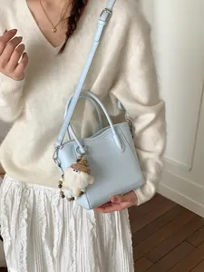 Sac seau minimaliste bleu clair avec breloque en peluche et bandoulière réglable