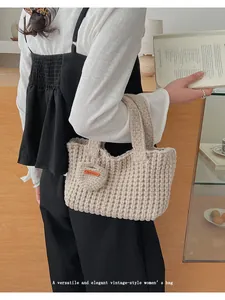 Primer plano del bolso de punto beige hecho a mano con colgante de corazón Hand Made