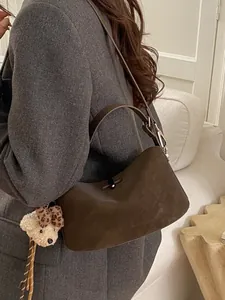 Borsa baguette minimalista verde oliva in pelle scamosciata con ciondolo a orsetto