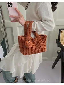 Detalle de bolso de punto hecho a mano naranja con colgante de corazón Hand Made