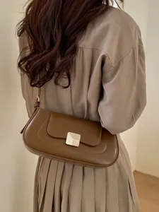 Minimalist brown leather baguette bag with square silver buckle and adjustable strap
