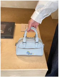 Detailansicht der hellblauen Boston Bag mit Lychee-Textur und Pony-Stickerei-Dekoration