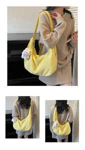 Detail view of bright yellow crescent tote bag with cute white plush bunny charm