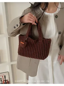 Detalle de bolso de ganchillo marrón oscuro con textura ondulada y colgante de corazón