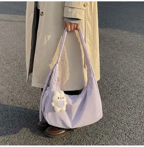 Detail of lavender canvas crescent tote bag with cute white rabbit plush charm