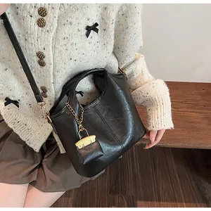 Close-up of black bucket bag with lychee grain texture and golden lock charm