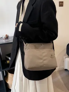 Khaki nylon tote bag with GK logo and wide woven strap for daily commuting