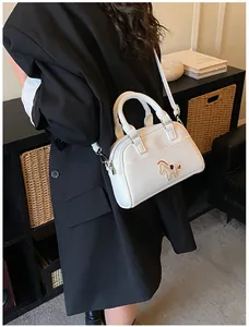 Detail einer weißen Baguette-Tasche mit flauschiger Pony-Stickerei und Silberakzenten