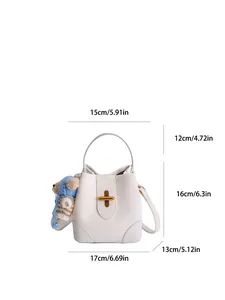 Weiße Leder-Beuteltasche mit Goldverschluss und blau gestreiftem Bärenanhänger, modern