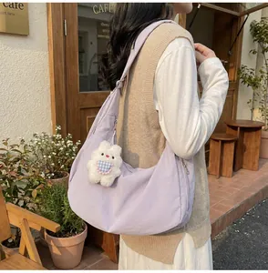 Outdoor shot of light purple quilted hobo bag with cute white plush bunny charm detail