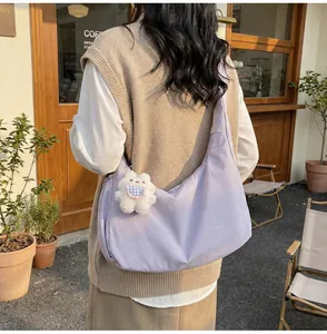 Detailed side view of light purple crescent canvas tote bag with a cute bear charm