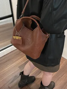 Caramel brown vintage bucket bag with mini pouch detail shown as a crossbody tote