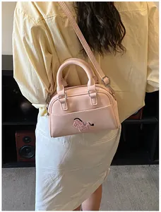Detail der rosa Baguette-Tasche mit süßer Tierstickerei und silbernen Beschlägen