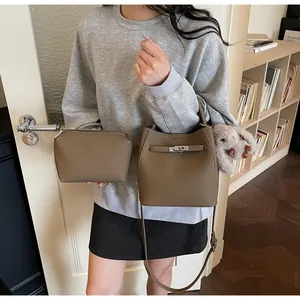 Dettaglio della borsa a secchiello in pelle grigia con chiusura e pochette abbinata