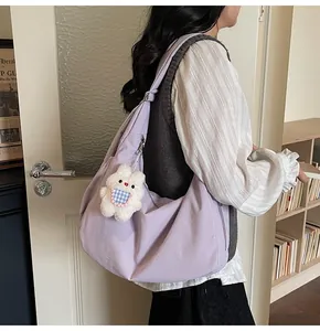 Padded lavender tote bag with rabbit charm shown in a casual lifestyle shoulder carry