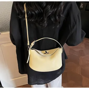 Model view of creamy yellow crescent baguette bag with silver turn-lock and dual straps