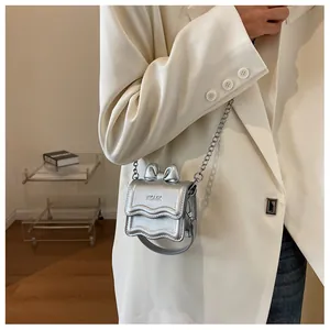 Detail of silver square bag featuring a 3D bow decoration and wavy edge design